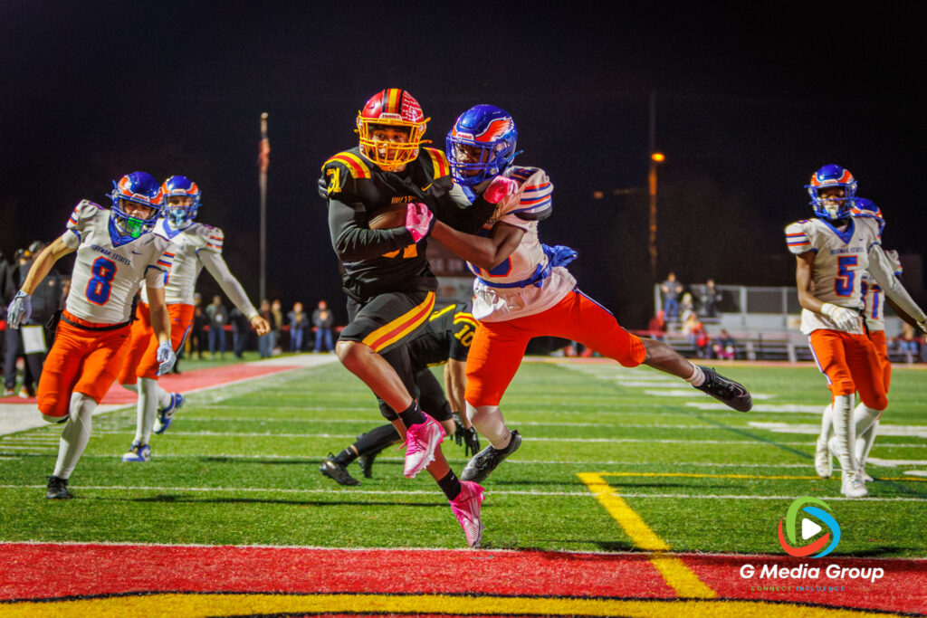 Batavia DB Elijah Gonzalez (31) secures the final touchdown of the night, despite the challenge of a Hoffman Estates defender, during the fourth quarter of the 56-0 victory in the IHSA Class 7A playoff opener.