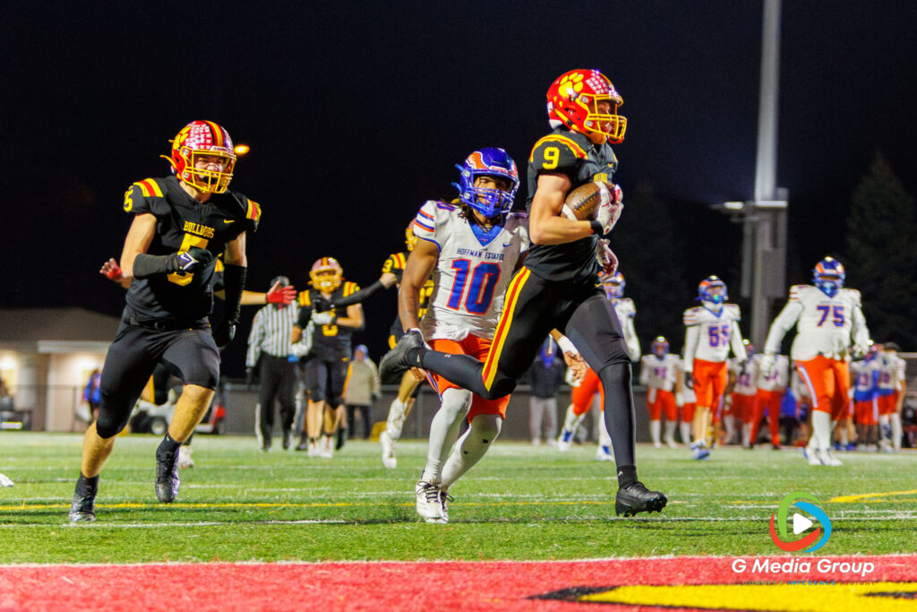 Batavia Nick Jansey (9) runs toward the end zone on a second-quarter touchdown, pursued by Hoffman Estates defender Quan Fields (10), during the Bulldogs' 56-0 playoff victory.