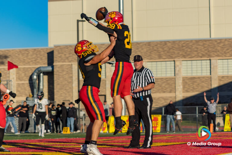 Batavia High School football player Steven Bannos lifts up Henry Hahn following his fourth-quarter touchdown against Glenbard North, helping secure the Bulldogs' victory, November 15, 2025. (Photo Credit - Zachary Gebis)