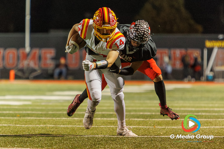 Batavia's Brennon Zeng (#14) attempts to break free from a tackle during the IHSA Class 7A Football Playoffs Second Round Game 19 against Glenbard East on Friday, Nov. 7, 2025, in Lombard, IL. Batavia won 42-21. | Photo: Zachary Gebis