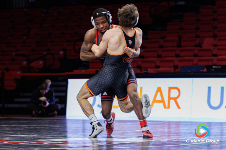 NIU’s Markel BAKER wrestles Gabe Whisenhunt 133-pound match. BAKER won via injury default against Oregon State in DeKalb, Illinois, on December 19, 2025. BAKER’S victory gave the Huskies an early boost in team points before the Beavers' mid-weight surge.