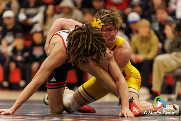 CMU's Mason Shrader gets direction from coaches on the mat side during his match against NIU's Landen Johnson