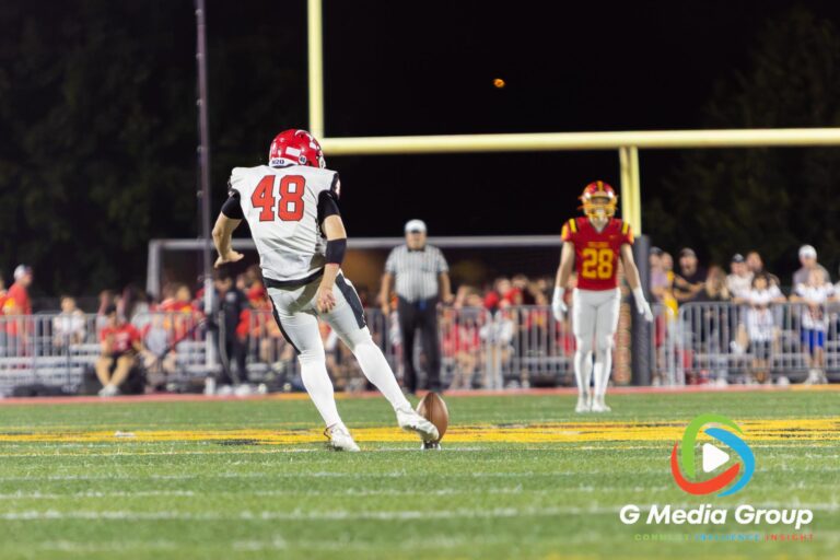 A Maine South kicker (#48) sends a kickoff downfield during the second quarter of a high school football game against Batavia in Batavia, Illinois, on August 21, 2026. The play followed a game-tying touchdown by Maine South with 3:18 remaining in the first half.