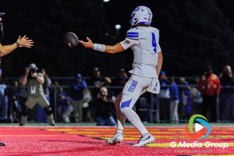 Geneva athlete Ben Peterson (4) hands the ball to the official after scoring a fourth-quarter touchdown against Batavia at Batavia High School in Batavia, Ill., on September 25, 2026. The score extended Geneva's lead to 49–35 with 5:15 left in regulation.