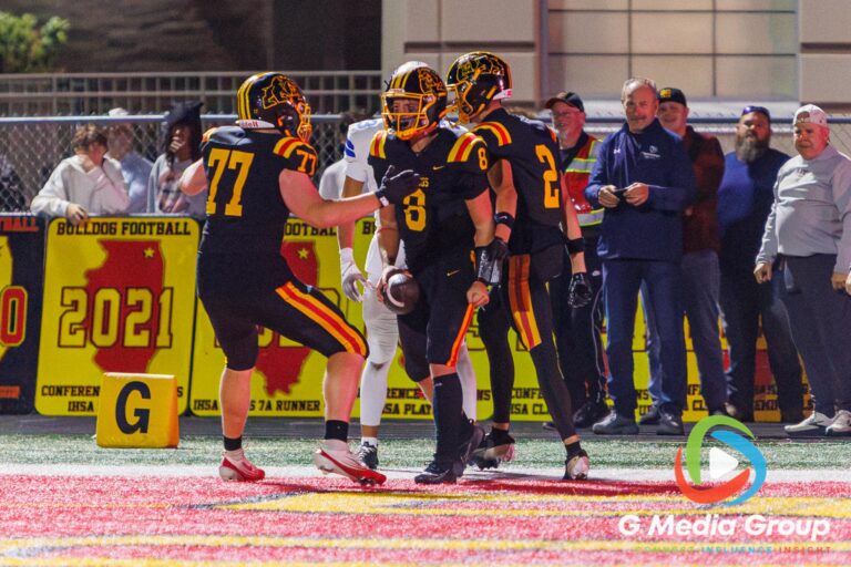 Batavia running back Michael Vander Luitgaren (8) celebrates with teammates after he scores his third touchdown of the evening against Geneva at Batavia High School in Batavia, Ill., on September 25, 2026. The score tied the game at 49–49 with 3:22 remaining in the fourth quarter.