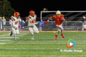 Batavia ball carrier (#0) rushes downfield as Wheaton Warrenville South defenders #43 and #25 pursue during the first quarter of a varsity football matchup at Bulldog Stadium in Batavia, Illinois, on October 16, 2026.