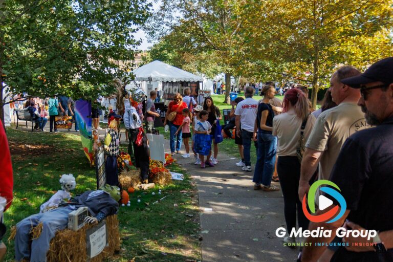 Attendees walk along a pathway lined with handcrafted scarecrows during the 41st annual Scarecrow Weekend on Saturday, Oct. 10, 2026, in downtown St. Charles, Ill.