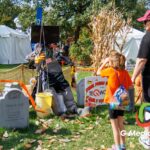 A young visitor interacts with the Teqworks scarecrow display during the 41st annual Scarecrow Weekend on Saturday, Oct. 10, 2026, in downtown St. Charles, Ill.