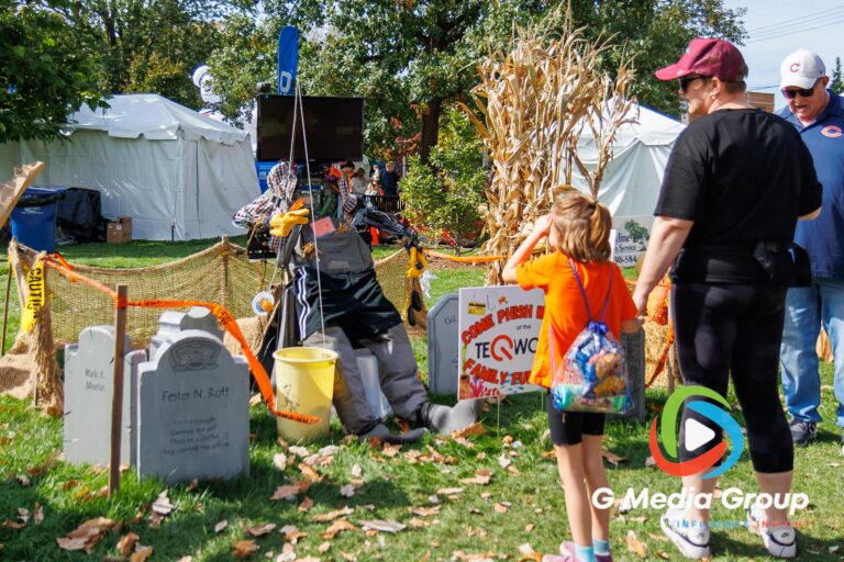 A young visitor interacts with the Teqworks scarecrow display during the 41st annual Scarecrow Weekend on Saturday, Oct. 10, 2026, in downtown St. Charles, Ill.