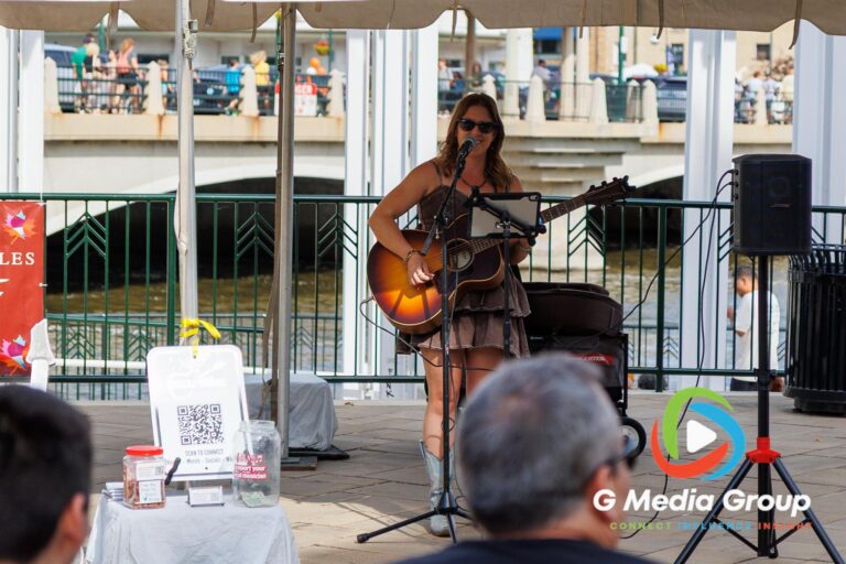 Musician Nicole DeVine plays guitar and sings on stage near 1st Street Plaza during the 41st annual Scarecrow Weekend on Saturday, Oct. 10, 2026, in downtown St. Charles, Ill.